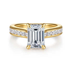 Gabriel & Co. ER17098E8Y44JJ 14 karat yellow gold Classic engagement ring, front view of an emerald cut center between broad shoulders holding channel set round diamonds