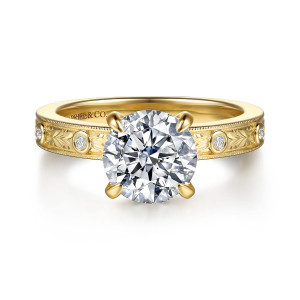 Gabriel & Co. ER17374R8Y44JJ 14 karat yellow gold Victorian engagement ring, front view of a round center on four prongs above an engraved band with bezel set diamonds