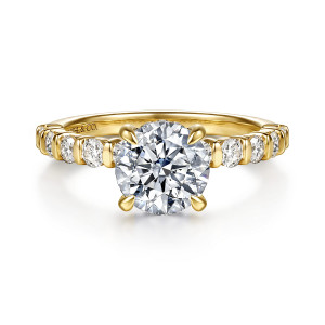 Gabriel & Co. ER17418R6Y44JJ 14 karat yellow gold Contemporary engagement ring, front view of a round center held by four slender prongs above bar set round diamonds