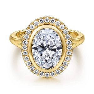 Gabriel & Co. ER17429O12Y44JJ 14 karat yellow gold Contemporary engagement ring, front view of a bezel set oval center inside a round diamond halo with a beaded outer edge