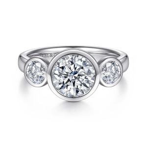 Gabriel & Co. ER17433R6W44JJ 14 karat white gold Contemporary engagement ring, front view of a round center in a bezel between two smaller bezel set side stones