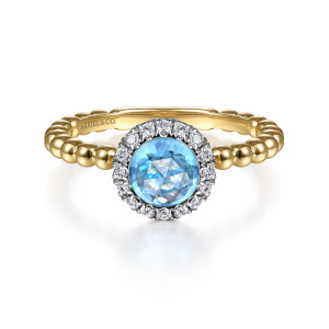 Gabriel & Co. LR51790Y45BT 14 karat yellow gold Bujukan ring, front view of the blue stone with its frame of diamonds above a beaded band