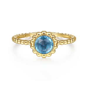 Gabriel & Co. LR51824Y4JBT 14 karat yellow gold Bujukan ring, front view of a round blue stone in a bezel with a scalloped beaded rim