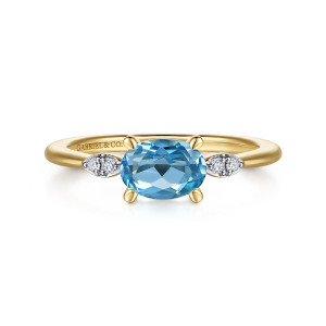 Gabriel & Co. LR52245Y45BT 14 karat yellow gold Color ring, front view of a blue oval stone set sideways with a diamond pair at each side