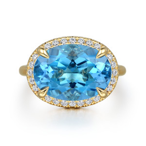 Gabriel & Co. LR52486Y45BT 14 karat yellow gold Color ring, top view of the blue oval stone ringed by round diamonds and held by pointed prongs