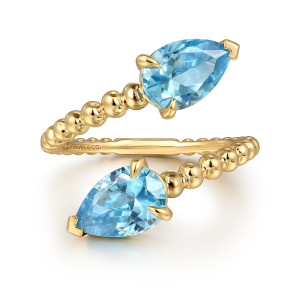 Gabriel & Co. LR52566Y4JBT 14 karat yellow gold Bujukan ring, front view of the two pear shaped blue stones facing opposite ways at the passing ends