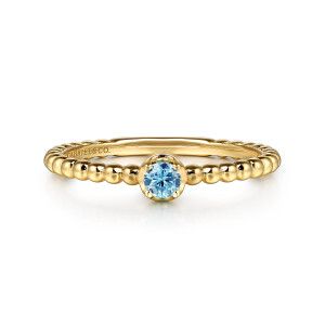 Gabriel & Co. LR52692Y4JBT 14 karat yellow gold Bujukan ring, front view of the blue stone in its raised cup on the beaded band