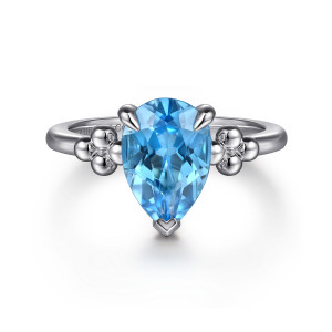 Gabriel & Co. LR52853SVJBT sterling silver Bujukan ring, front view of the pear shaped blue stone in prongs with metal bead clusters on both sides