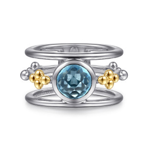 Gabriel & Co. LR52930MZJBT sterling silver and 14 karat yellow gold Bujukan ring, front view of a round blue stone in a bezel between two rails and bead clusters