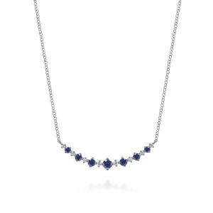 Gabriel & Co. NK8063W45SA 14 karat white gold Color necklace, front view of graduated blue round stones alternating with tiny diamonds on a curved bar