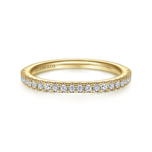 Gabriel & Co. WB15242R4Y44JJ 14 karat yellow gold Starlight wedding band, front view of a hoop with round diamonds between fine pointed prong tips and a maker's mark