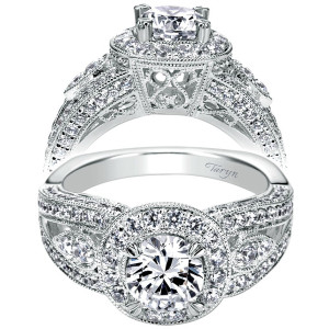 Taryn TE6407W44JJ 14 karat white gold engagement ring, front and raised views of a round center in a milgrain halo over filigree gallery, wide pave shoulders