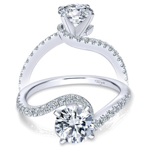 Taryn TE7232W44JJ 14 karat white gold engagement ring, angled view of a round center with a pave rail curving across its top on a bypass shank