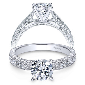 Taryn TE7529W44JJ 14 karat white gold engagement ring, front view of a round center above engraved scrollwork shoulders edged with milgrain and a pave row