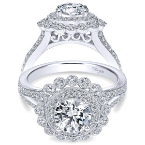 Taryn TE7542W44JJ 14 karat white gold engagement ring, front view of a round center in a pave halo ringed by bezel set rounds, split pave shoulders