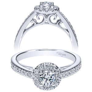 Taryn TE98577W44JJ 14 karat white gold engagement ring, front view of a round center in a halo of larger rounds above bold scroll openwork