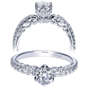 Taryn TE98578W44JJ 14 karat white gold engagement ring, front view of a round center in a tall pierced crown head with scrolled shoulder cutouts