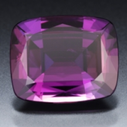 A cushion-cut alexandrite, purple in lamplight