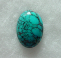 An oval turquoise cabochon veined with dark matrix